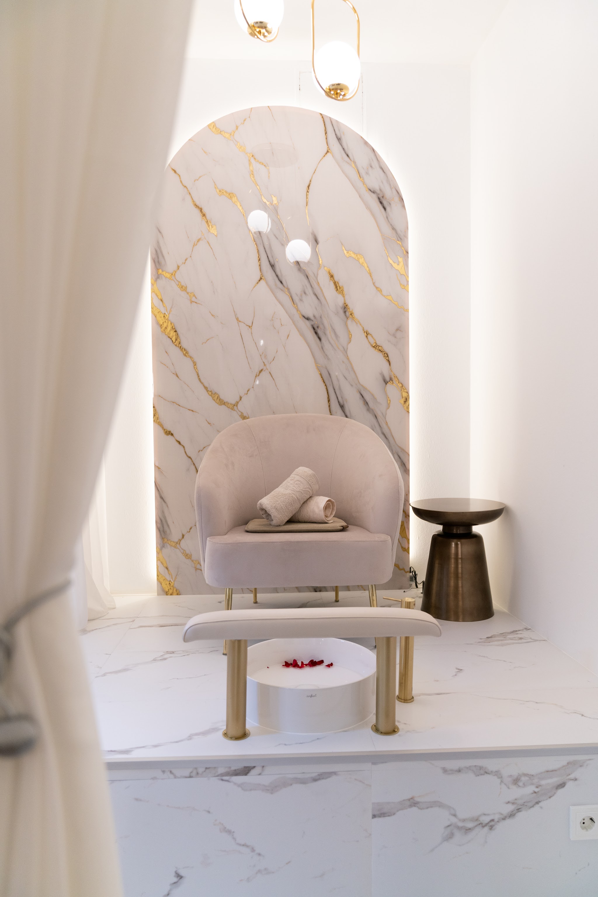 Pediküre-Sessel mit Handtüchern und Rosenblättern